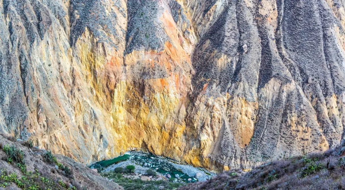 Steep canyon walls above a green valley floor